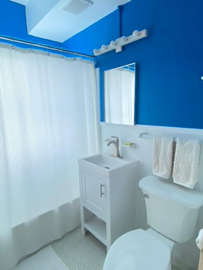 Newer vanity and toilet were installed in this pretty blue bathroom | Image 20