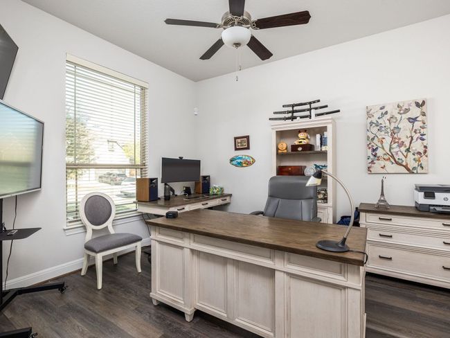 Office space featuring a ceiling fan, dark wood-style floors, and baseboards | Image 13