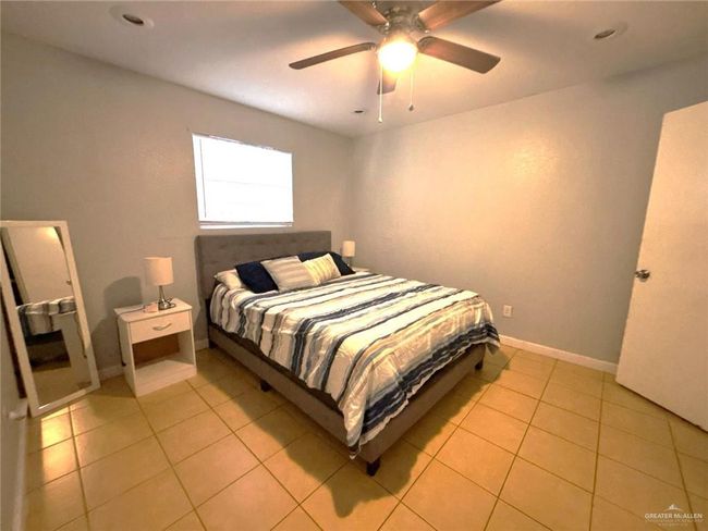 Bedroom featuring baseboards, ceiling fan, and light tile patterned flooring | Image 11