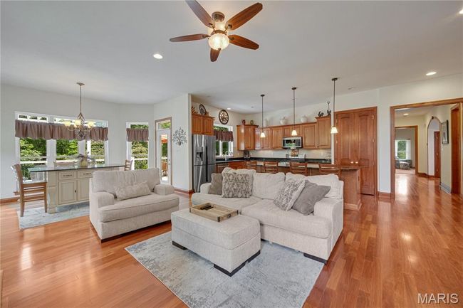 Living area with recessed lighting, light wood-style floors, ceiling fan, and a chandelier | Image 15