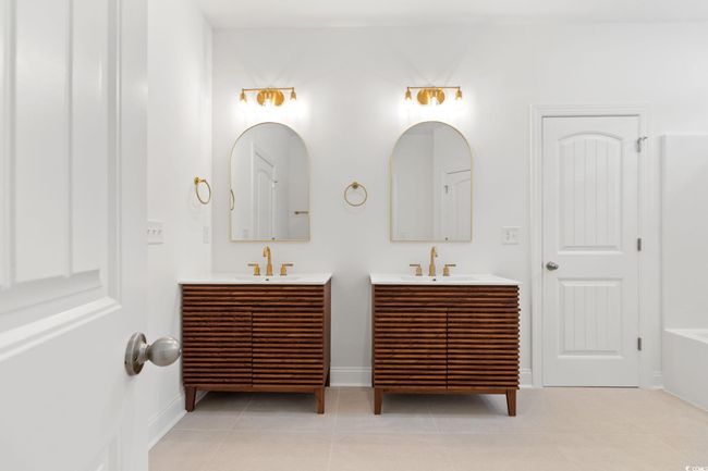 Full bath with two vanities, tile patterned floors, and a bath | Image 15
