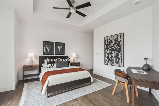 Bedroom with a tray ceiling, baseboards, a ceiling fan, and wood finished floors | Image 16