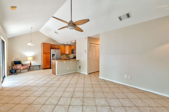 View from the spacious living room towards the dining area with pendant light and kitchen. | Image 7