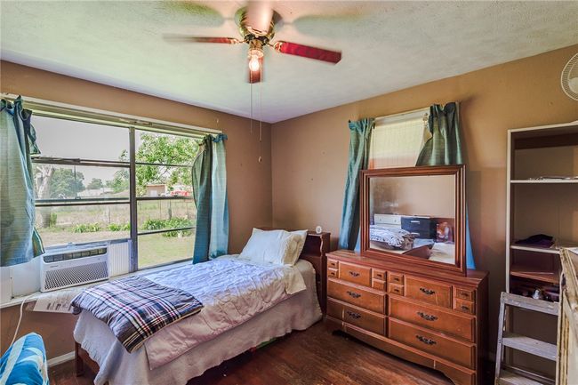 Bedroom with dark wood finished floors, cooling unit, ceiling fan, and a textured ceiling | Image 22