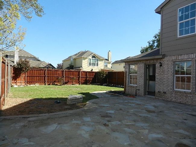 Fenced backyard with a patio area | Image 19