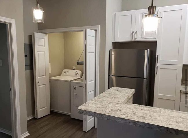 Laundry area featuring washer and clothes dryer, dark wood finished floors, and baseboards | Image 5