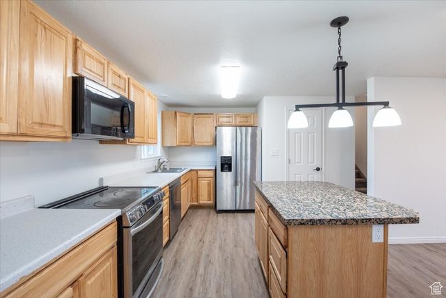 Kitchen featuring light brown cabinetry, stainless steel appliances, and light wood finished floors | Image 8