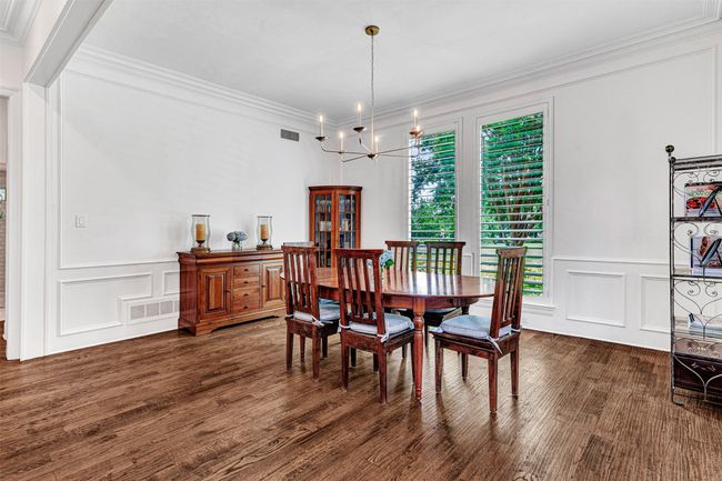 The formal dining room continues the hardwood floors, extensive crown moldings and bright, sunny windows accented with plantation shutters. Plenty of space for any size and style of furniture. | Image 7