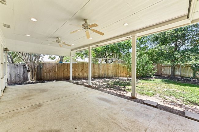 Newer fences in backyard with oversized covered back patio with ceiling fans | Image 31