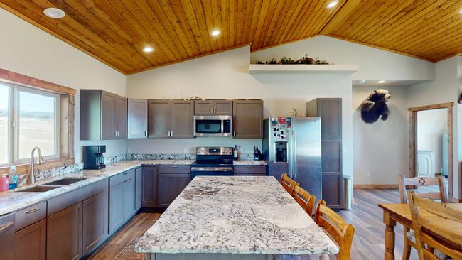 Kitchen with stainless steel appliances, wood ceiling, lofted ceiling, and a sink | Image 8