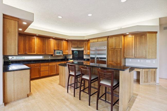 Gorgeous custom kitchen with ample counter space. Unique under cabinet windows are a standout! | Image 7