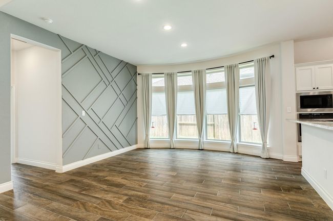 A formal dining area with large, floor-to-ceiling windows that allow for lots of natural light. | Image 20
