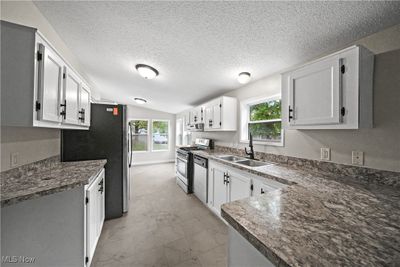 Kitchen featuring lofted ceiling, appliances with stainless steel finishes, plenty of natural light, and sink | Image 2