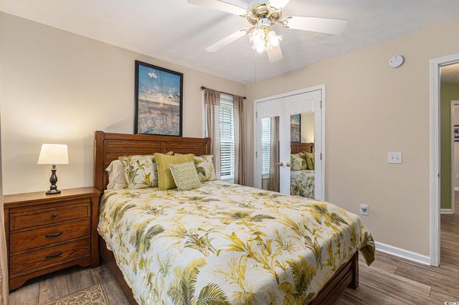 Bedroom with wood finished floors, baseboards, a closet, and a ceiling fan | Image 25