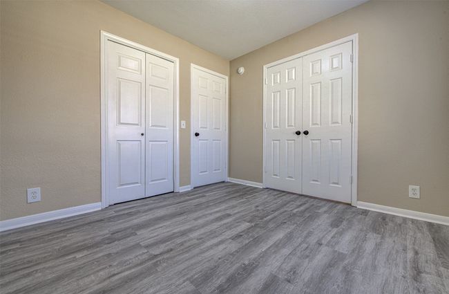Unfurnished bedroom featuring wood finished floors and baseboards | Image 12