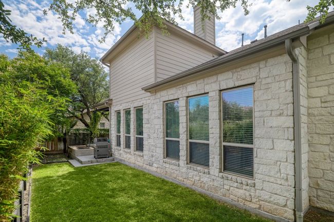 View of side of property featuring a patio, stone siding, and a chimney | Image 35