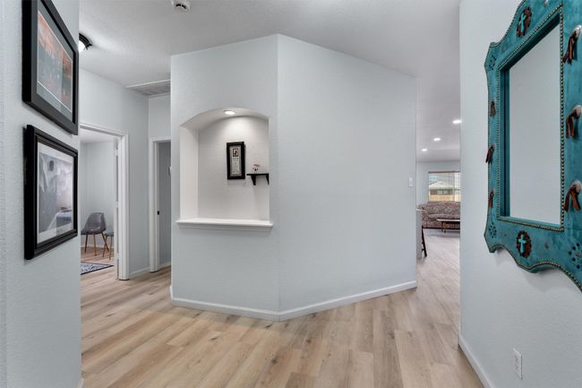 Hall with light wood-style floors and arched niche | Image 5