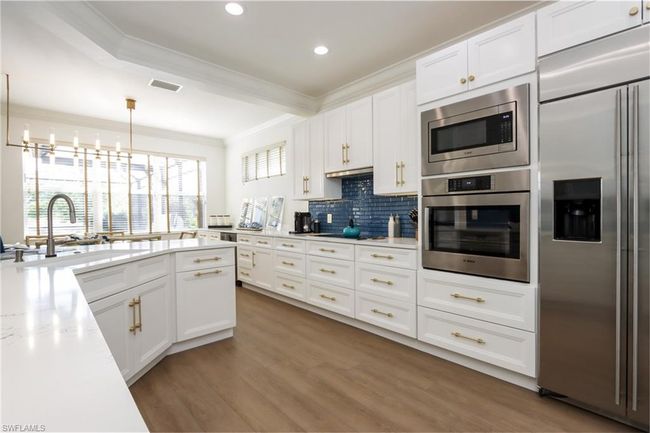 Kitchen featuring built in appliances, crown molding, tasteful backsplash, white cabinets, and recessed lighting | Image 7