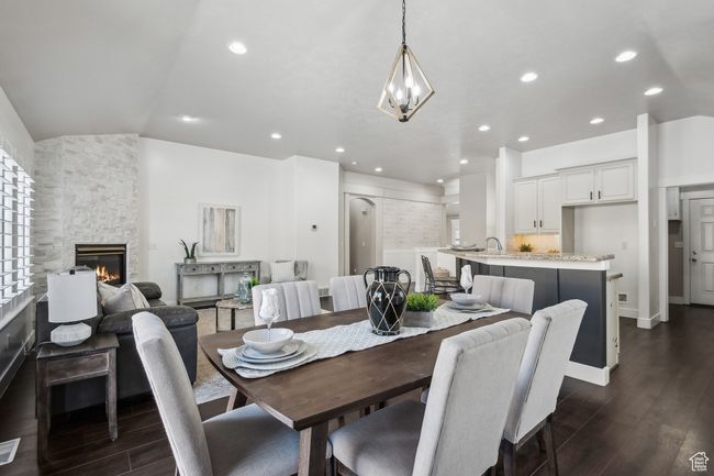 Dining space featuring lofted ceiling, sink, dark hardwood / wood-style floors, and a stone fireplace | Image 12