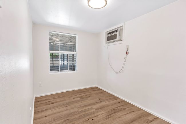 Spare room with a wall mounted AC and light wood-style floors | Image 32