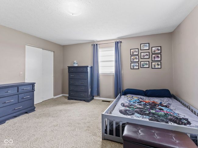bedroom with baseboards, light colored carpet, and a textured ceiling | Image 26