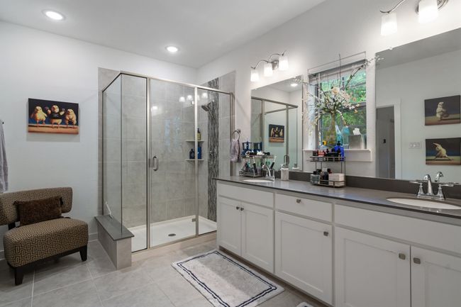 Bathroom with double vanity, tile patterned flooring, a shower stall, and recessed lighting | Image 18