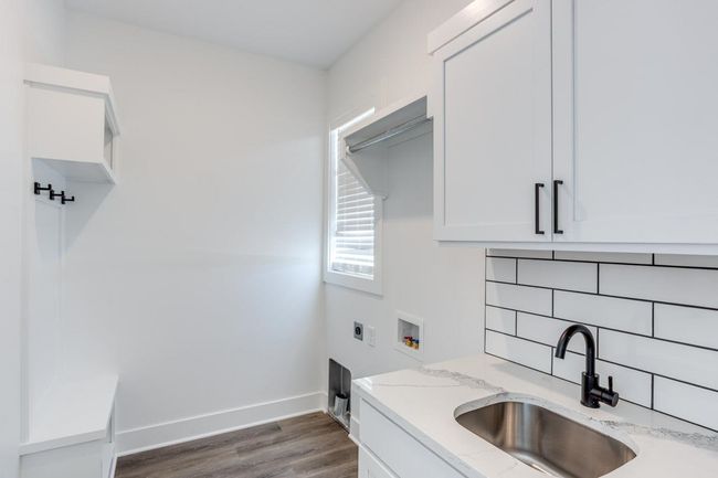 Laundry area with washer hookup, cabinet space, hookup for an electric dryer, dark wood-type flooring, and baseboards | Image 12