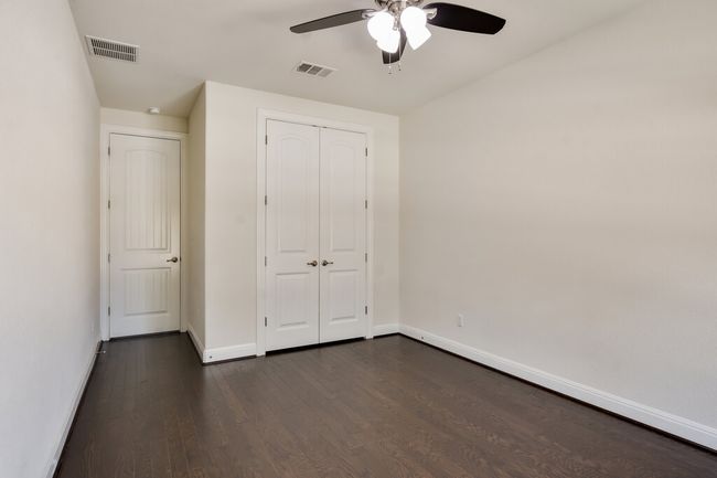 Unfurnished bedroom featuring dark wood-type flooring, a closet, and ceiling fan | Image 29
