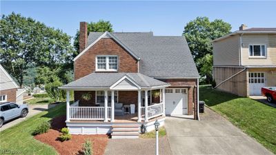 View of front of property with a front lawn, a garage, and a porch | Image 1