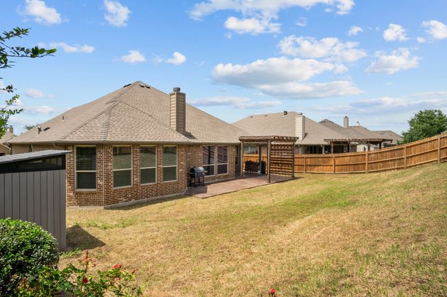 Back of house with brick siding, a patio, fence, a pergola, and a shingled roof | Image 5