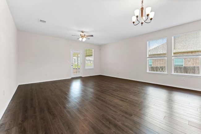 Empty room with a chandelier, ceiling fan, and dark wood-style flooring | Image 27