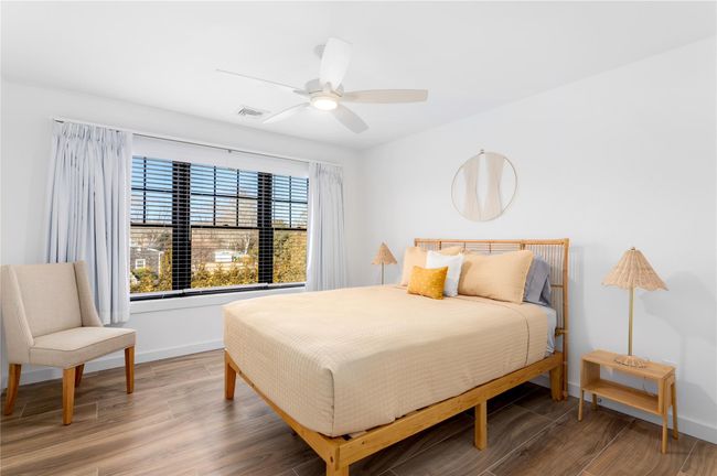 Bedroom featuring a ceiling fan, wood finished floors, visible vents, and baseboards | Image 20