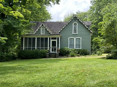 The lush front yard with the front entrance and generous screened porch. | Image 1