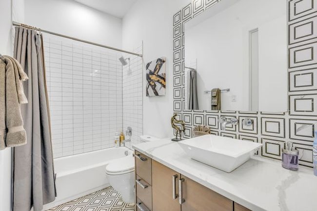 Full bathroom with shower / bath combination with curtain, toilet, tile walls, and vanity | Image 21