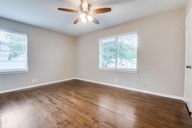 Bed room featuring healthy amount of natural light, ceiling fan, and dark real wood flooring | Image 16