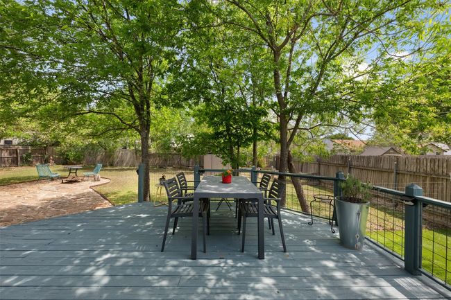 View of patio / terrace featuring a wooden deck, a fenced backyard, a fire pit, and outdoor dining space | Image 23