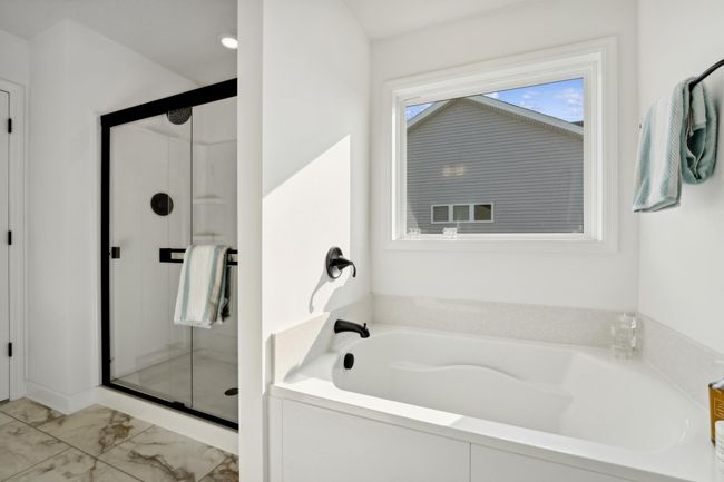 (Photo of a decorated model, actual homes finishes will vary) The private primary ensuite bath offers a wonderful luxury height double vanity with a quartz counter top, a soaking tub and separate shower. | Image 11