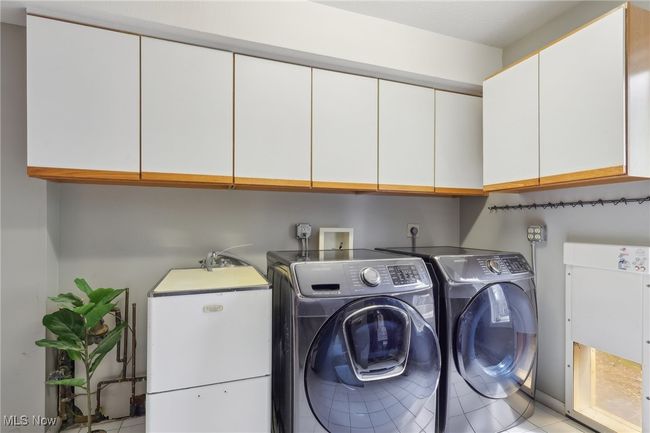 Laundry room with light tile patterned floors, cabinet space, and independent washer and dryer | Image 32