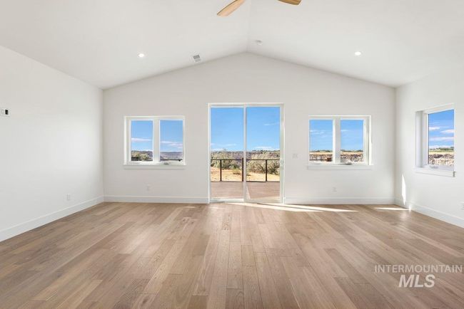 Unfurnished living room featuring light wood finished floors, a ceiling fan, recessed lighting, and lofted ceiling | Image 35