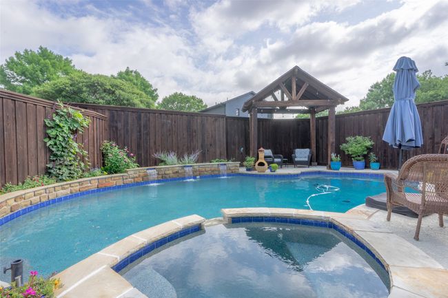 View of pool featuring a pool with connected hot tub and a fenced backyard | Image 26