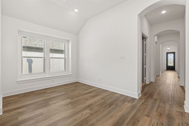 Unfurnished room featuring baseboards, wood finished floors, recessed lighting, arched walkways, and lofted ceiling | Image 25