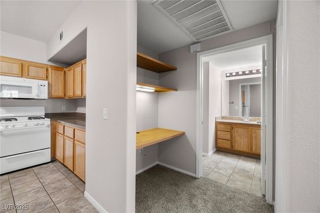 Kitchen featuring a sink, light tile patterned flooring, visible vents, and white appliances | Image 21