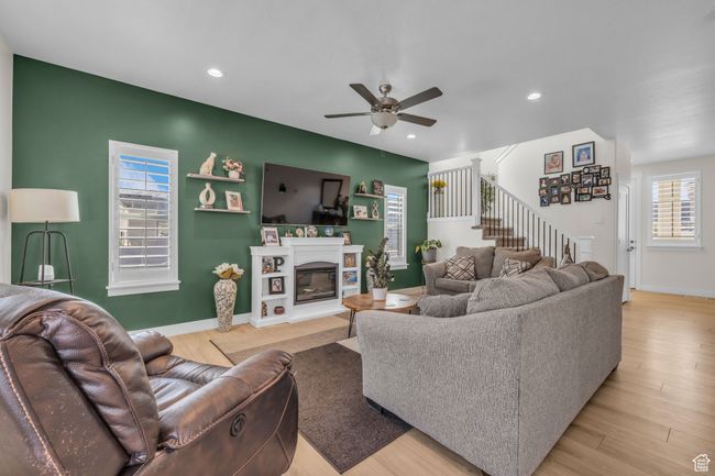Living room with recessed lighting, light wood-type flooring, stairs, and ceiling fan | Image 4