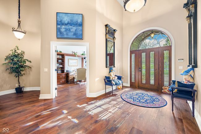 entrance foyer featuring a high ceiling, hardwood / wood-style floors, and baseboards | Image 11