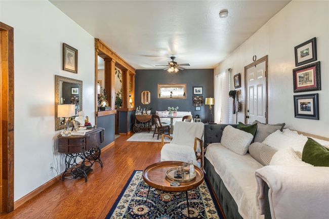 Living room featuring wood finished floors, ceiling fan, and baseboards | Image 8