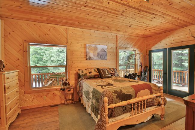 Office/bedroom featuring multiple windows, wooden ceiling, wood finished floors, and access to outside | Image 30