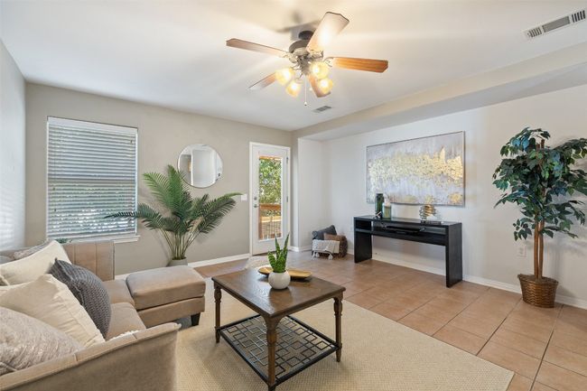 Living area featuring light tile patterned flooring, a ceiling fan, and baseboards | Image 15
