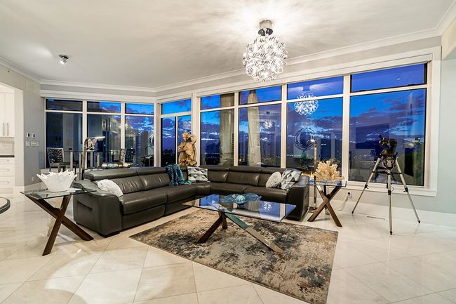 Tiled living room featuring crown molding and a chandelier | Image 13