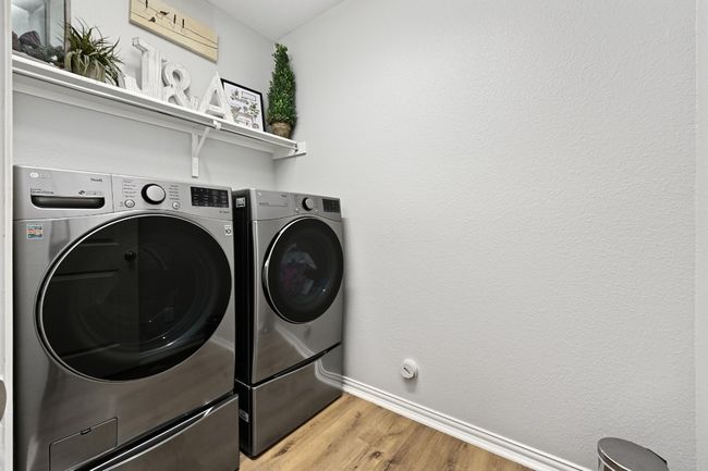 Laundry area with washer and clothes dryer and light wood finished floors | Image 24