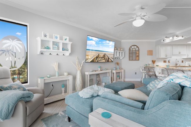 Living room with light wood-type flooring, ornamental molding, baseboards, and a ceiling fan | Image 10